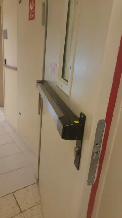 התקנת מוט לחיצה של ידית בהלה על דלת יציאת חירום מאש במבנה