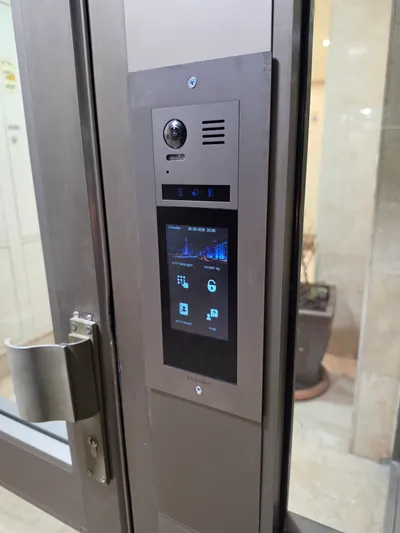 אינטרקום מסך מגע VisionNet בכניסת בניין, מצלמה ומסך פעיל עם תפריט בעברית