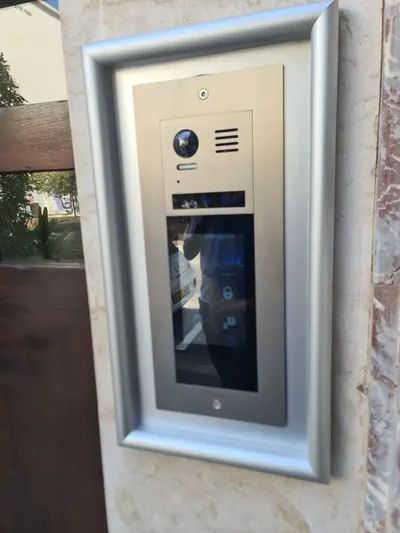 אינטרקום מסך מגע VisionNet בכניסת בניין, מבט מהצד על הפאנל המותקן בקיר שיש